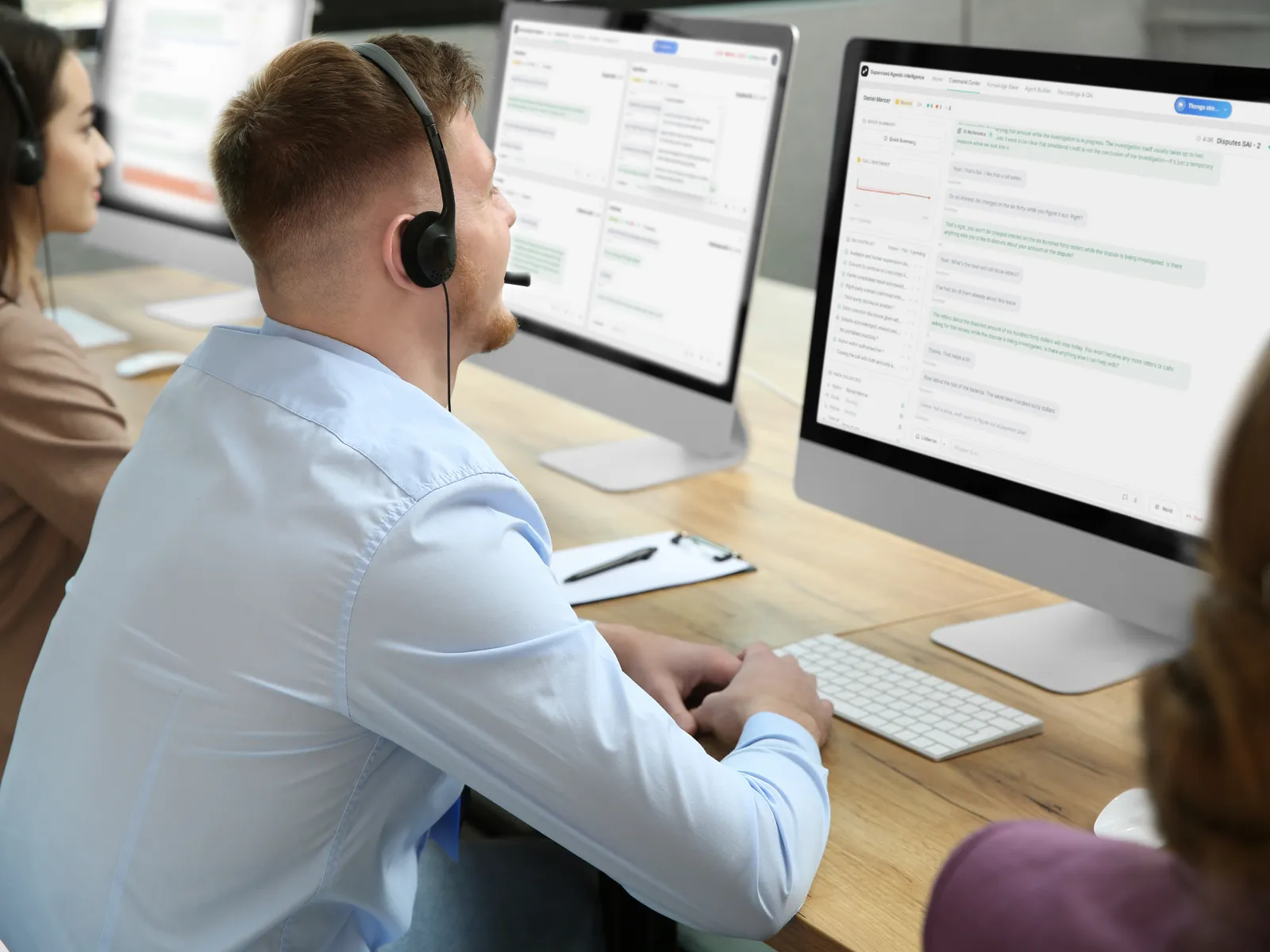 Agent working across two screens in a contact center office